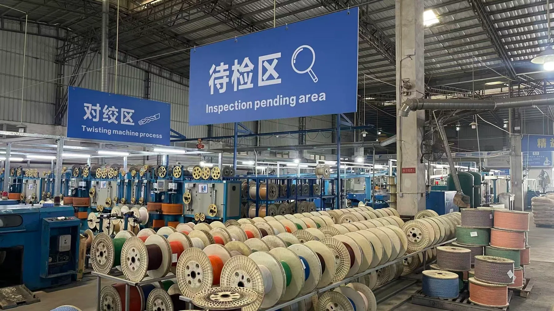 Cable reels in the pending-inspection area of a NexBridge partner factory